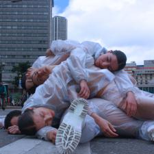 Personas acostadas en la calle una encima de la otra. 