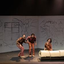 tres personas bailando, en una habitación con las paredes llenas de garabatos. 