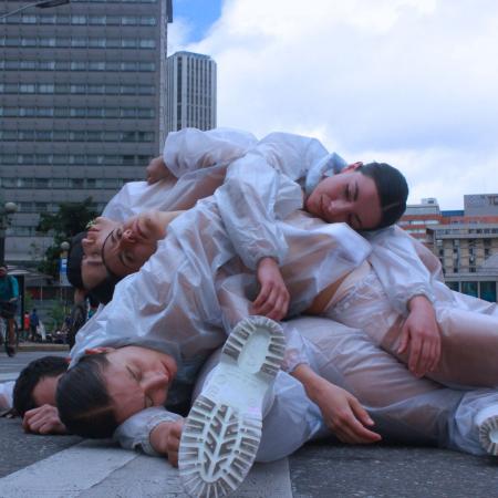Personas acostadas en la calle una encima de la otra. 
