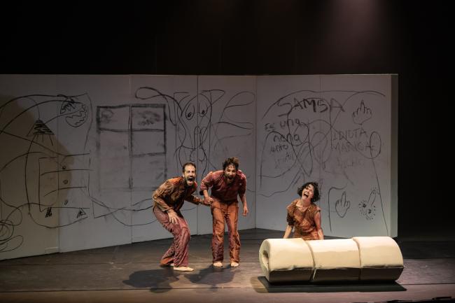 tres personas bailando, en una habitación con las paredes llenas de garabatos. 